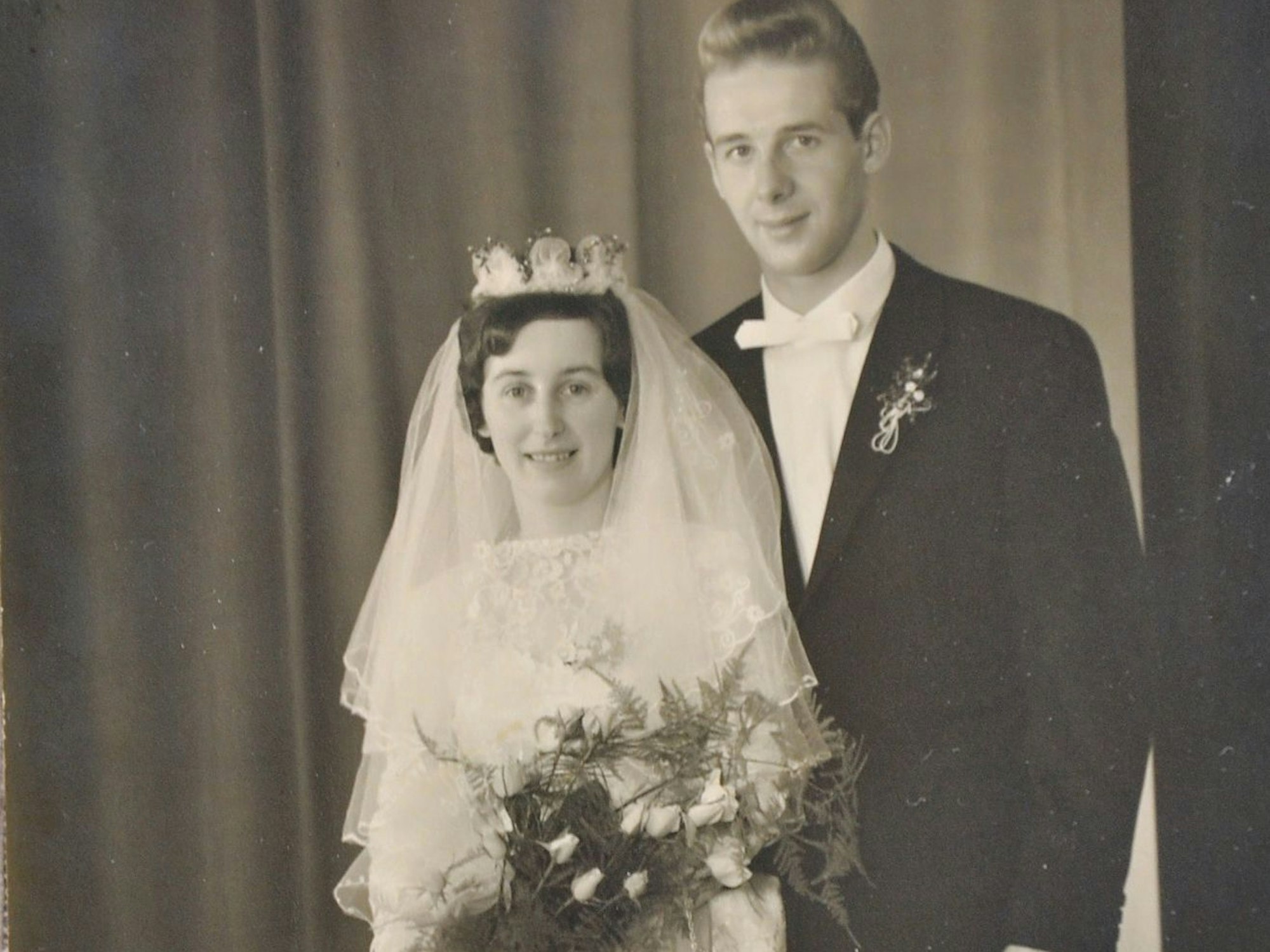 Die Eheleute Magdalena und Johann Bung wurden an ihrem Hochzeitstag fotografiert. Sie trägt ein weißes Kleid mit einem Diadem, er trägt Anzug und Fliege.
