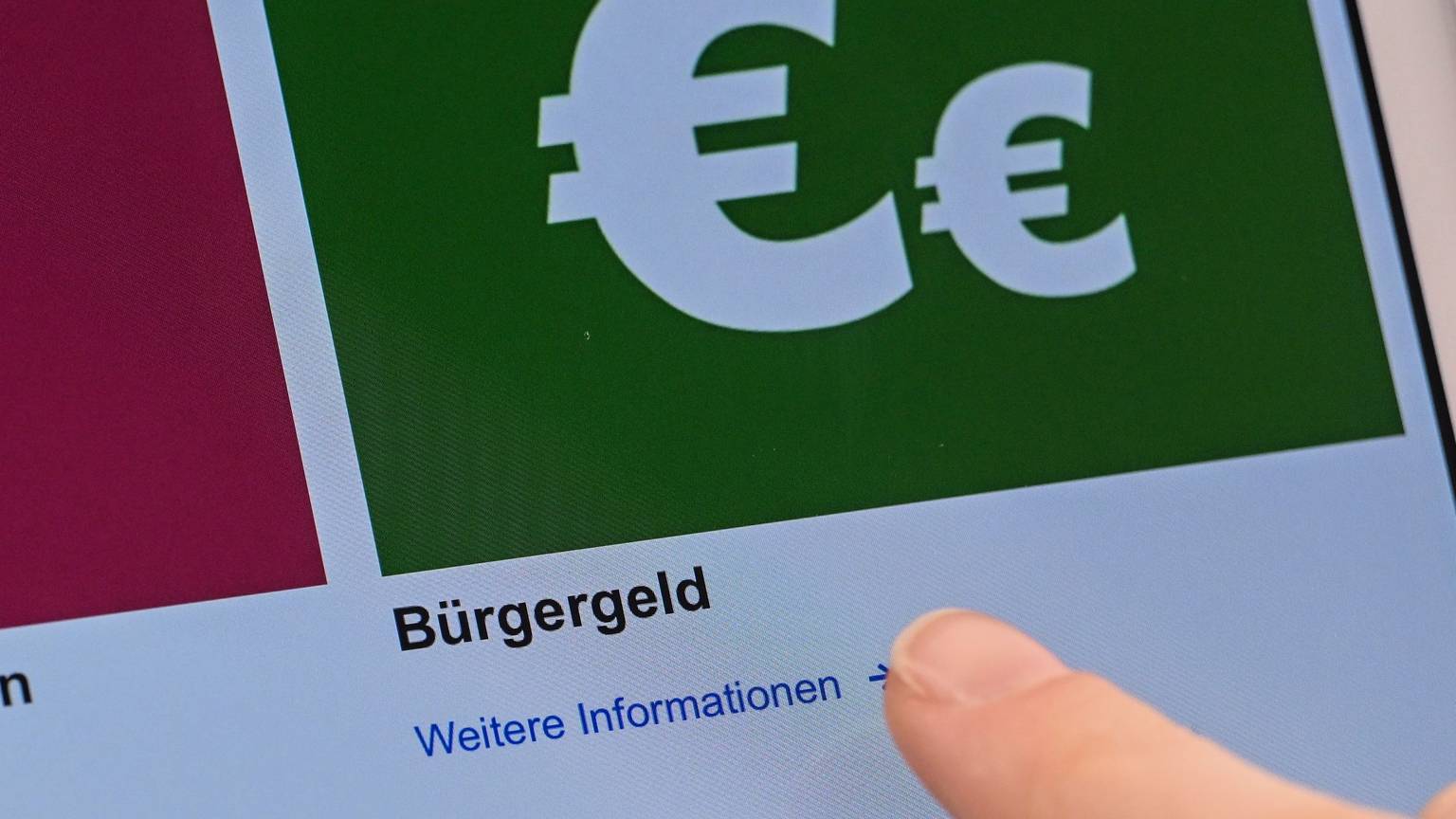 Auf einem Display im Jobcenter werden Onlineangebote rund um das Bürgergeld abgerufen.