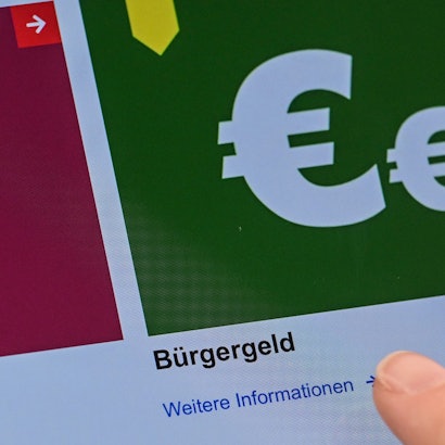 Auf einem Display im Jobcenter werden Onlineangebote rund um das Bürgergeld abgerufen.