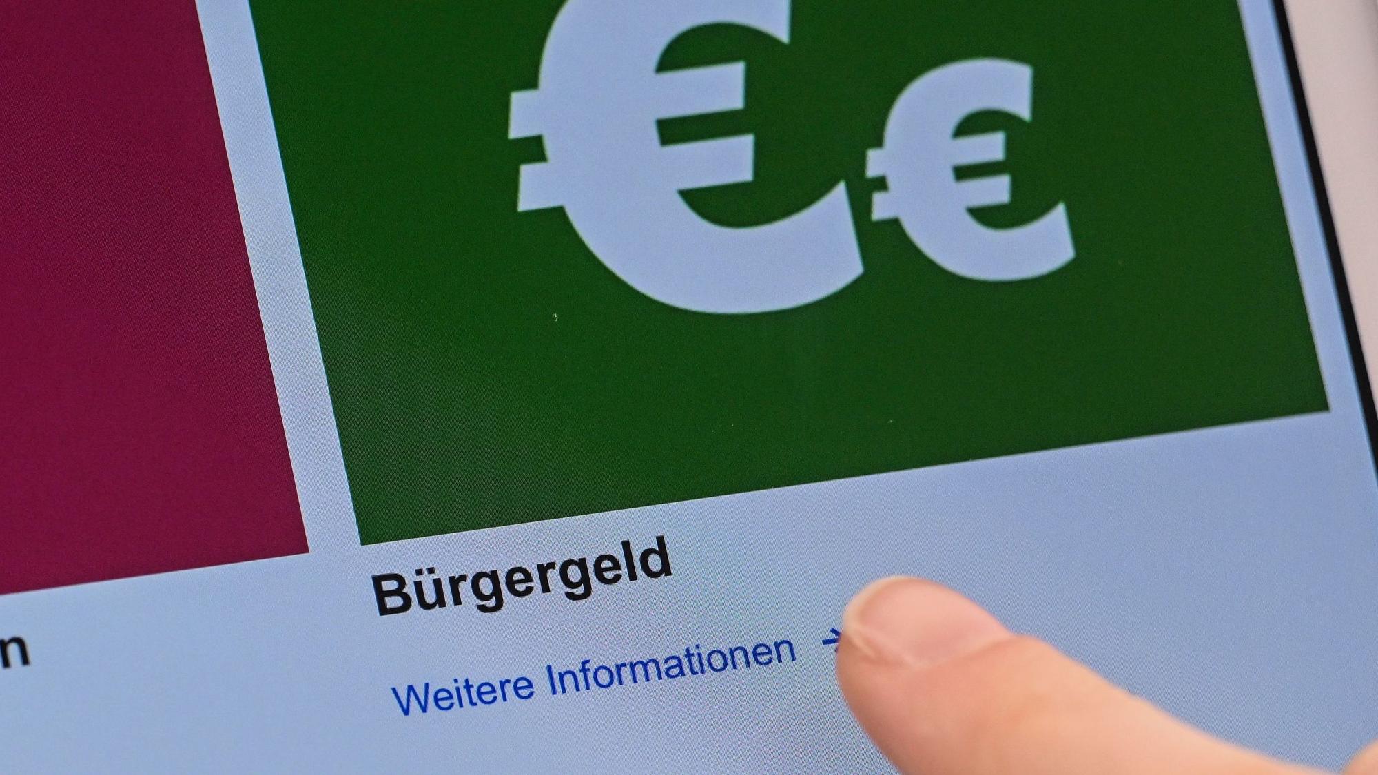 Auf einem Display im Jobcenter werden Onlineangebote rund um das Bürgergeld abgerufen.