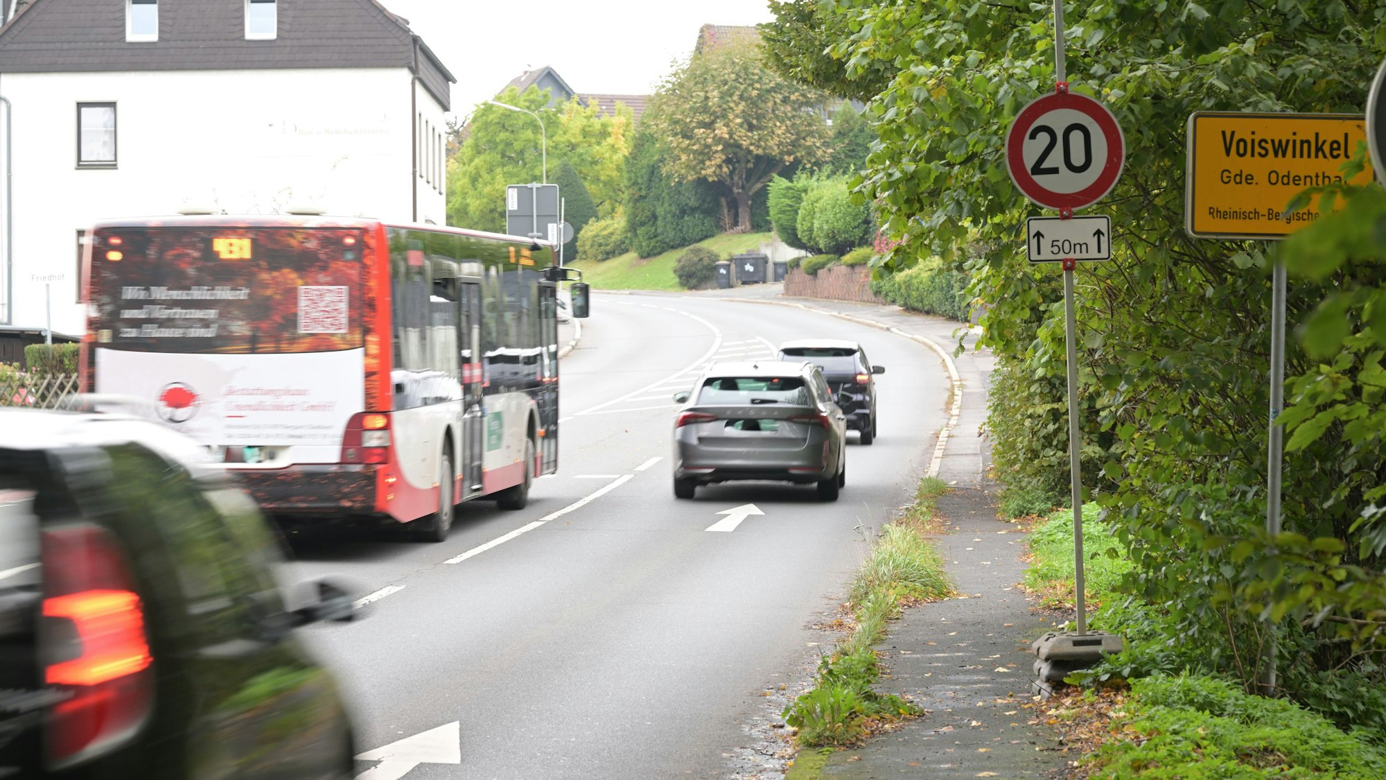 Eine stark befahrene Straße mit einem Bus und einem Tempo-20-Schild.