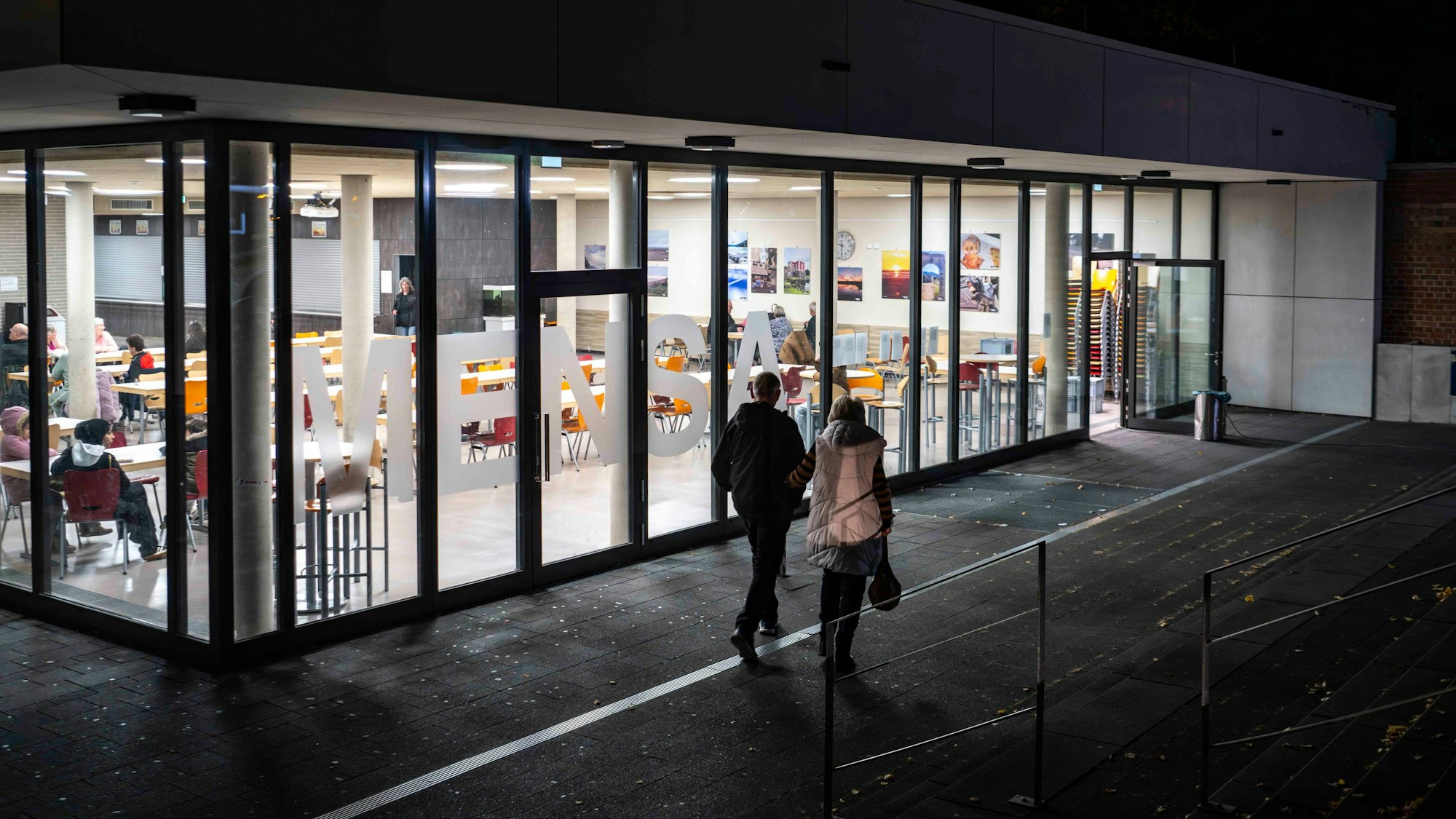 Das Bild zeigt die Mensa der Gesamtschule in Euskirchen. Zwei Menschen machen sich gerade auf den Weg zur Sammelstelle für die Evakuierten.