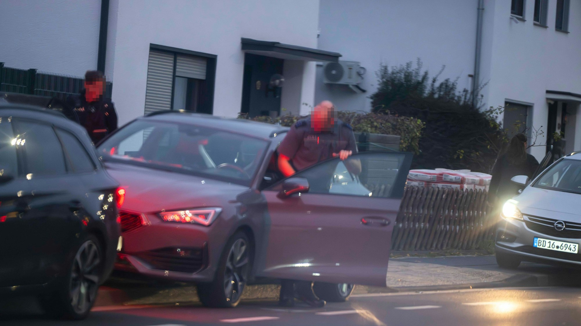 Das Bild zeigt einen Mann, der in Auto einsteigt.