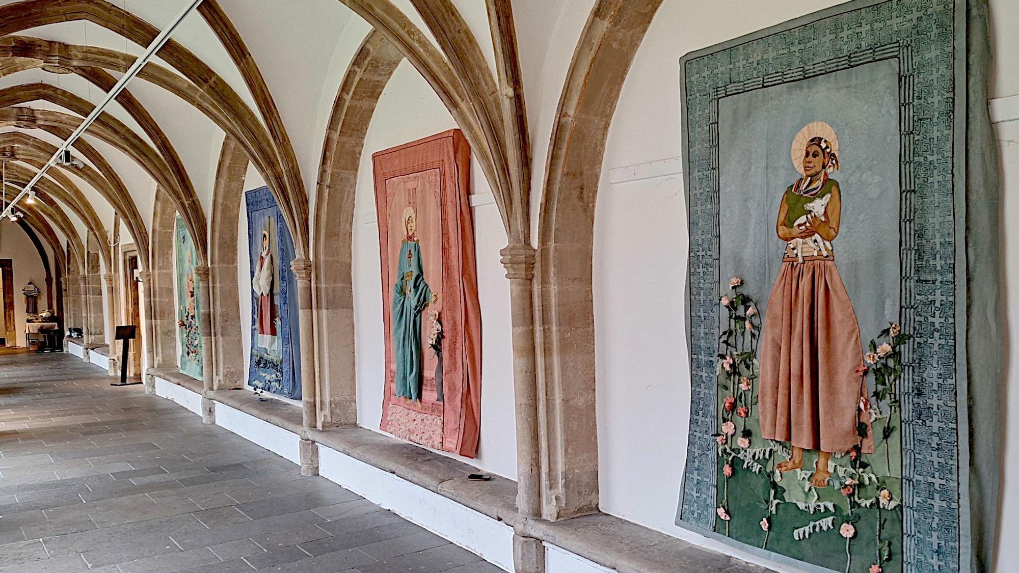Sicht auf den gotischen Kreuzgang des Klosters Steinfeld. In den Wandnischen hängen Textilien, die mit Blumen verziert wurden.