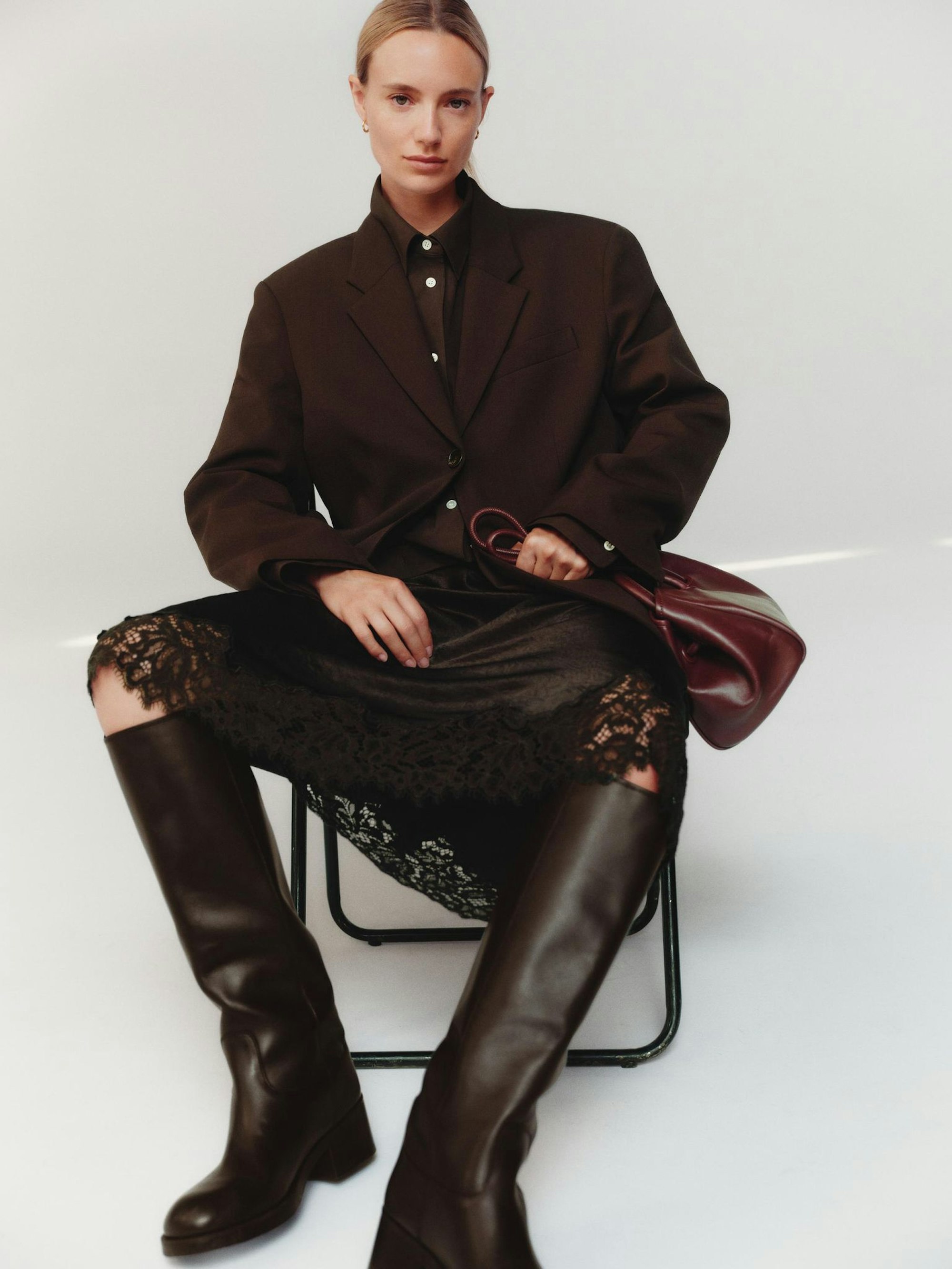 All-Brown-Styling: Schokobraun in verschiedenen Nuancen schafft Tiefe und Eleganz im monochromen Look, hier von Arket (Hemd ca. 89 Euro, Blazer ca. 169 Euro, Satinrock mit Spitze ca. 89 Euro, Stiefel ca. 299 Euro, Tasche ca. 149 Euro).