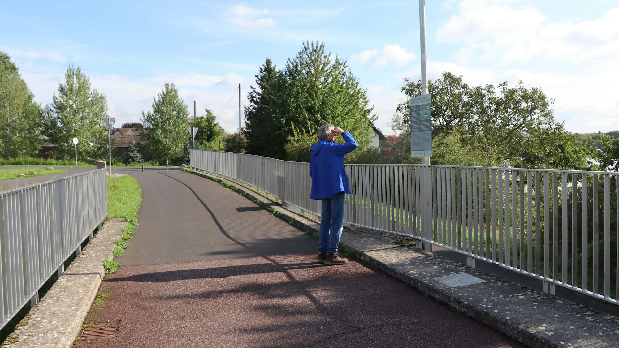 Eine Person steht auf einer Brücke.