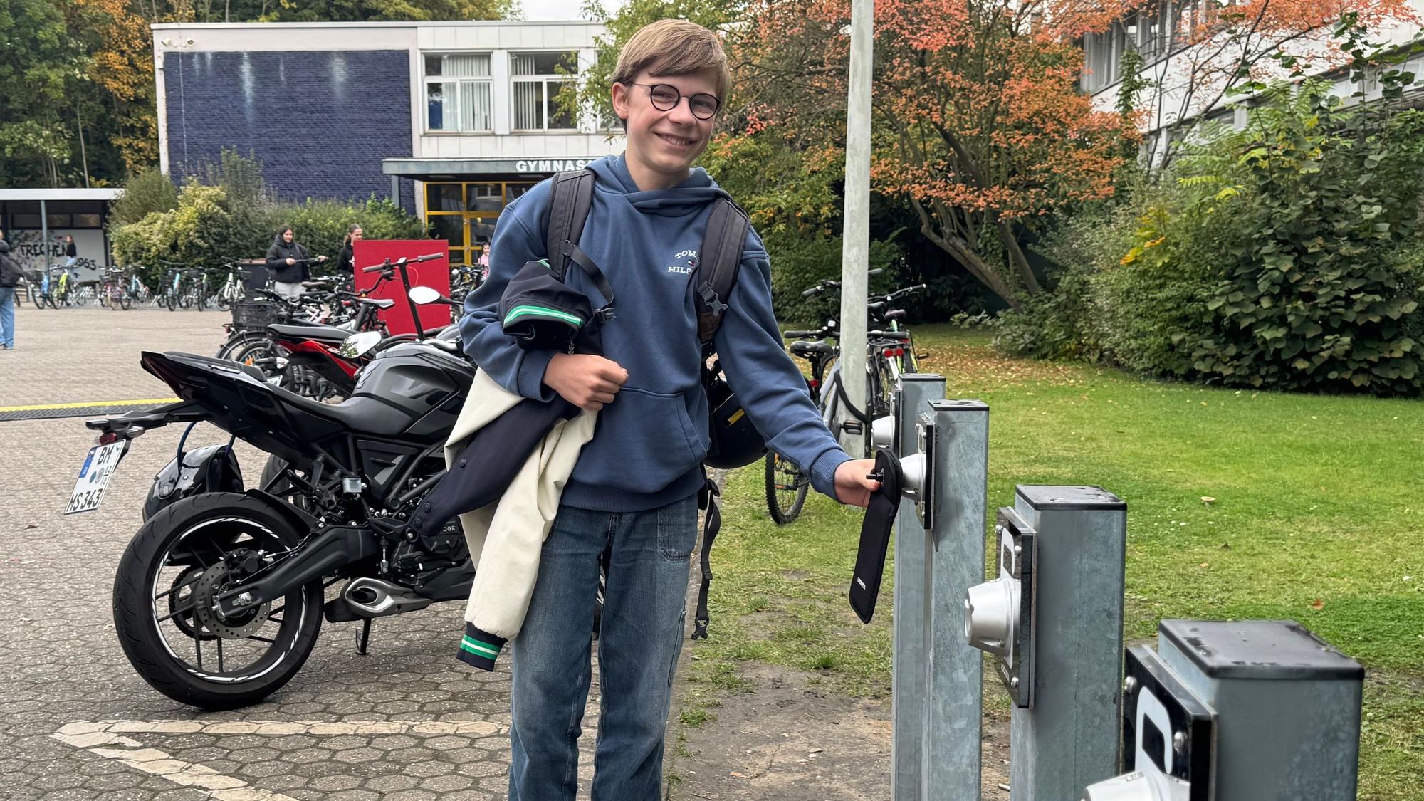 Auf dem Bild ist ein Schüler mit seinem Smartphone zu sehen.