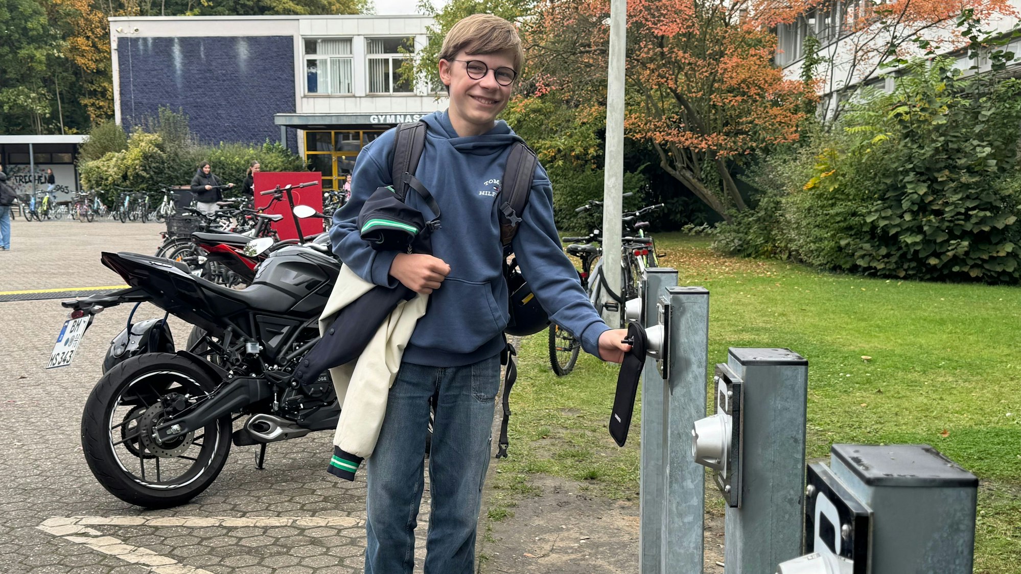 Auf dem Bild ist ein Schüler mit seinem Smartphone zu sehen.