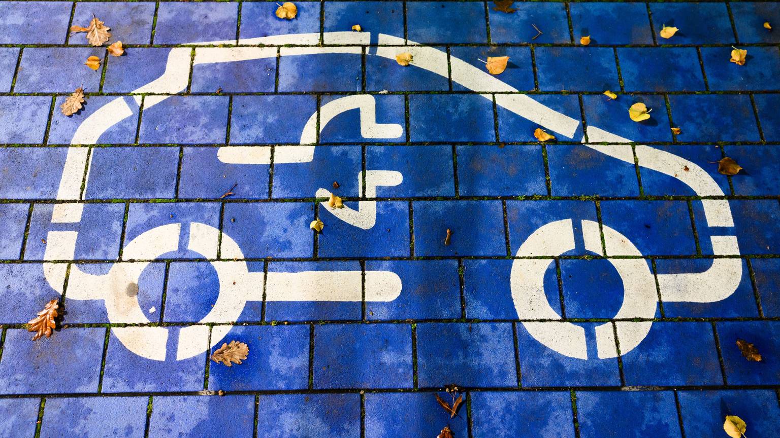 Ein Symbol markiert einen Parkplatz für Elektroautos an einem öffentlichen Schnellladepunkt. Vertreter von Politik, Herstellern und Zulieferern, Verbänden und Gewerkschaft sowie der Bundesländer mit Autoindustrie kommen zu einem sogenannten Autogipfel zusammen.