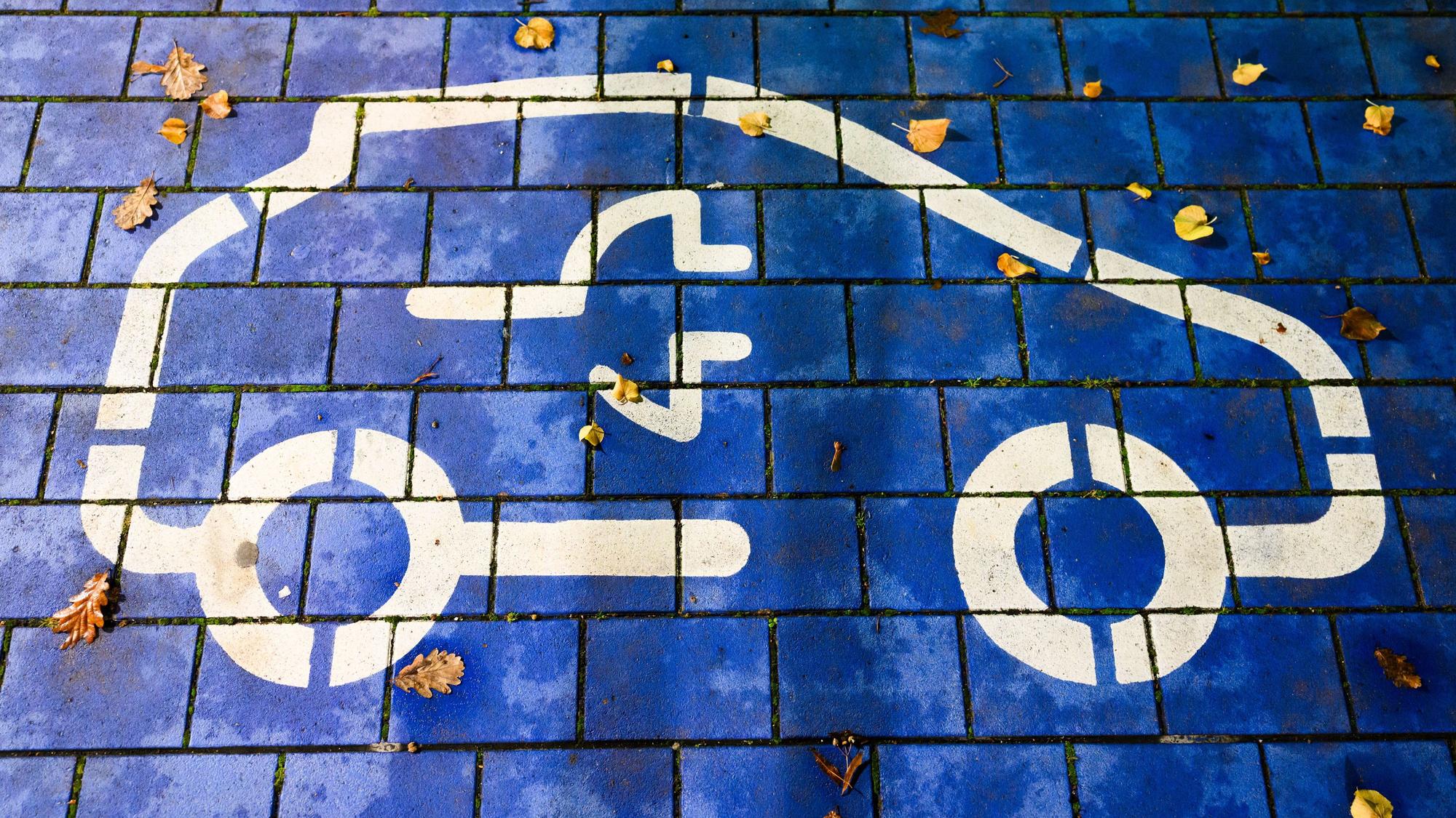 Ein Symbol markiert einen Parkplatz für Elektroautos an einem öffentlichen Schnellladepunkt. Vertreter von Politik, Herstellern und Zulieferern, Verbänden und Gewerkschaft sowie der Bundesländer mit Autoindustrie kommen zu einem sogenannten Autogipfel zusammen.