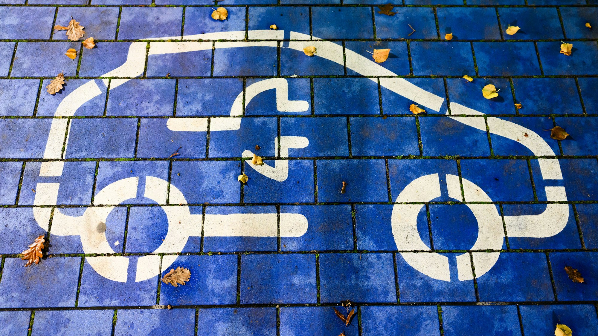 Ein Symbol markiert einen Parkplatz für Elektroautos an einem öffentlichen Schnellladepunkt. Vertreter von Politik, Herstellern und Zulieferern, Verbänden und Gewerkschaft sowie der Bundesländer mit Autoindustrie kommen zu einem sogenannten Autogipfel zusammen.