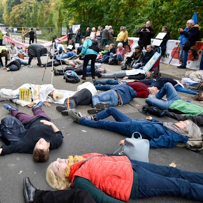 Das Bild zeigt Personen/ Demonstranten, die auf der Straße liegen.