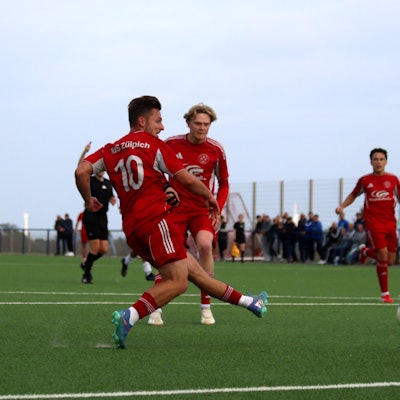 Devin Nickisch schießt aufs Tor, Tim Birkenheuer und im Hintergrund Marlon Große beobachten ihn.
