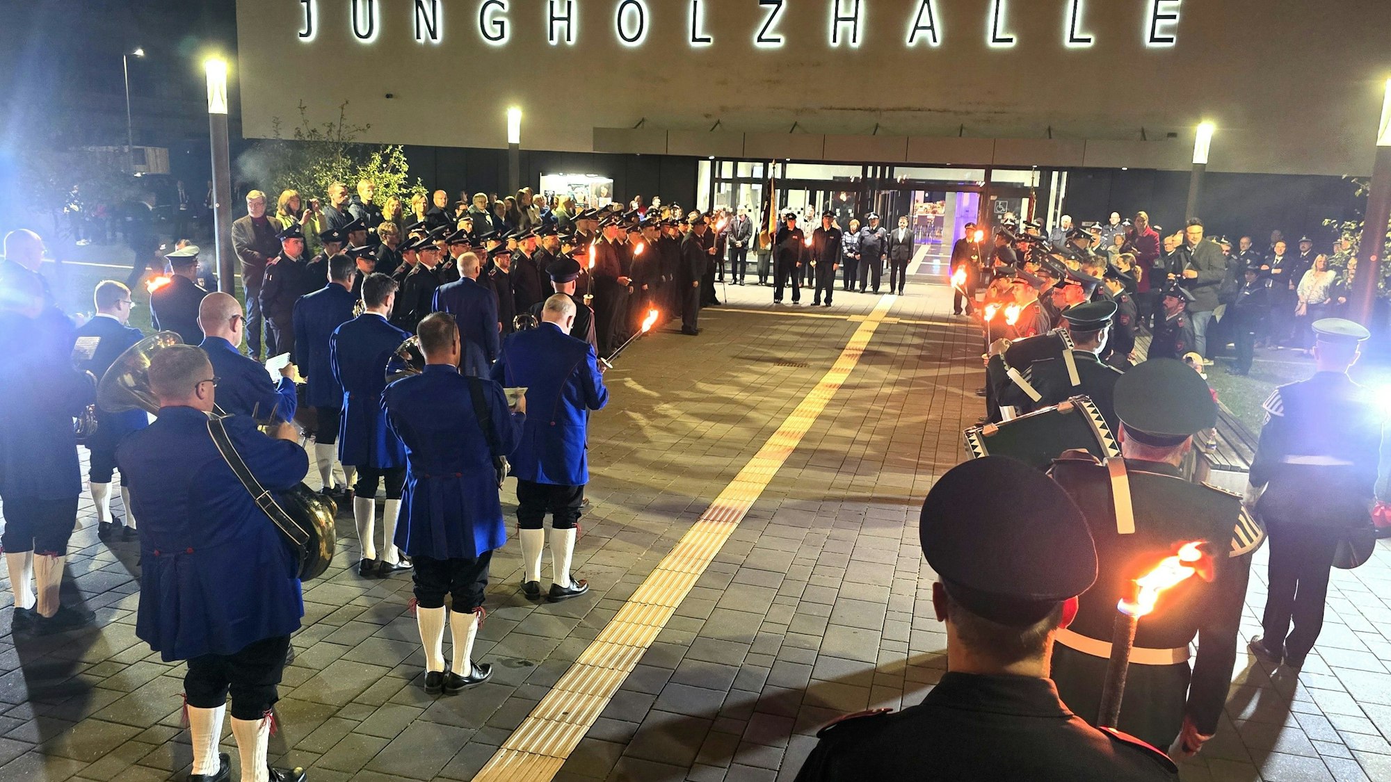 Vor der Halle haben sich Musiker versammelt, um den Zapfenstreich zu spielen.