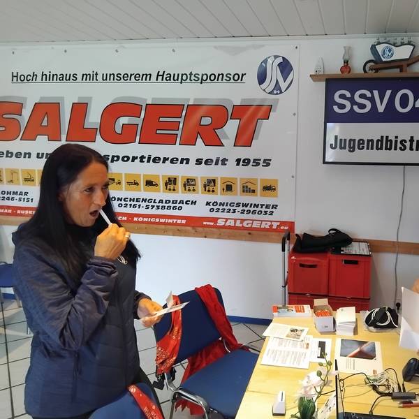 Mit dem Wattestäbchen streicht Claudia Radermacher, Ehrenamtlerin im SSV 04, über die Innenseite ihrer Wange, Leif Stockhausen tütet die Proben ein.