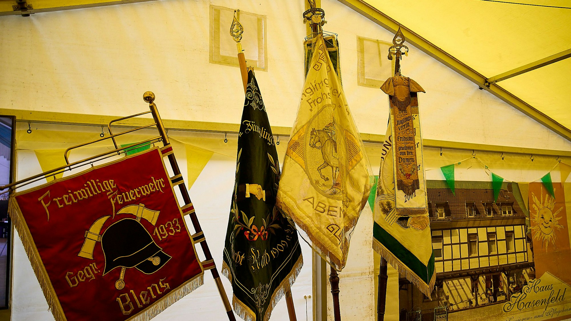 An einer Zeltwand stehen verschiedene Fahnen.