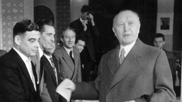 ARCHIV - Bundeskanzler Konrad Adenauer (r) gibt in Bonn seine Stimme für die Bundestagswahl 1957 ab (Archivfoto vom 15.09.1957).