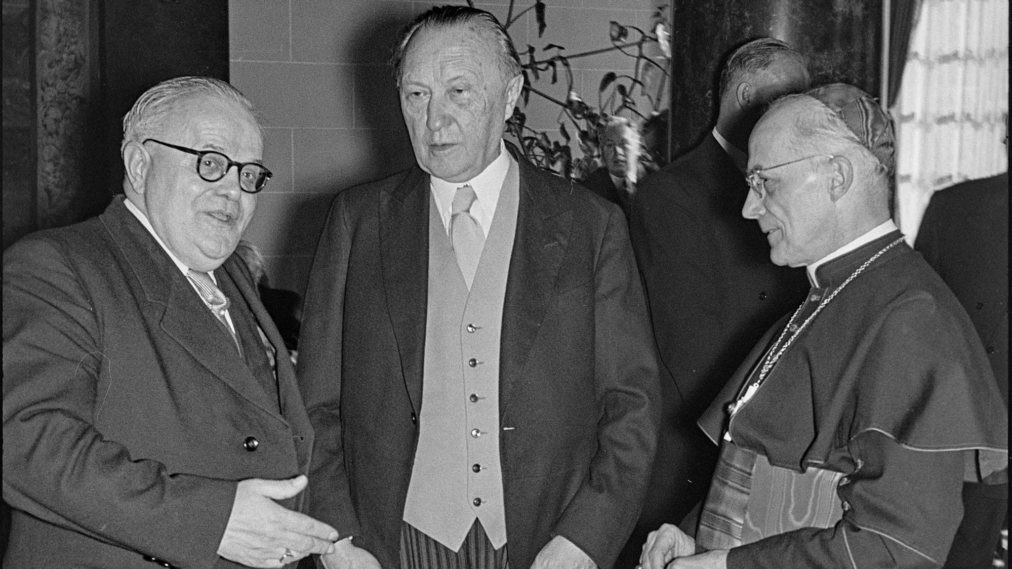 Köln - Feierlichkeiten zum 10jährigen Bestehen der Kölner Tageszeitung "Kölnische Rundschau" im Hotel Excelsior. - Im Bild v.l.: Rundschau-Herausgeber Dr. Reinhold Heinen, Bundeskanzler Konrad Adenauer und der Kölner Erzbischof Josef Kardinal Frings im Gespräch. - Foto vom 19.03.1956
