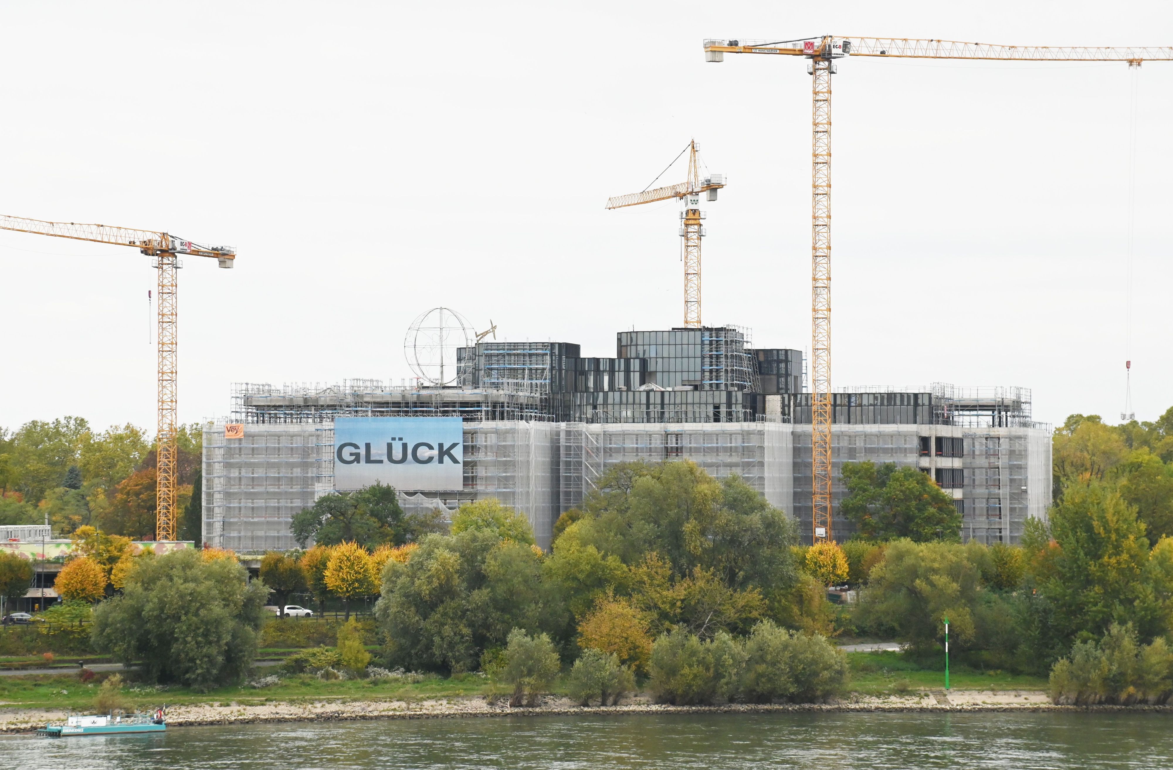 Das Gebäude der DEVK Versicherung in Köln ist teilweise eingerüstet. Daneben stehen Baukräne.