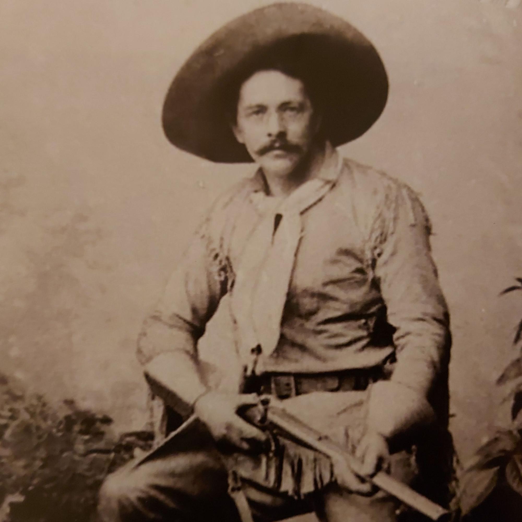 Ein Mann im Cowboyanzug hält ein Gewehr in der Hand