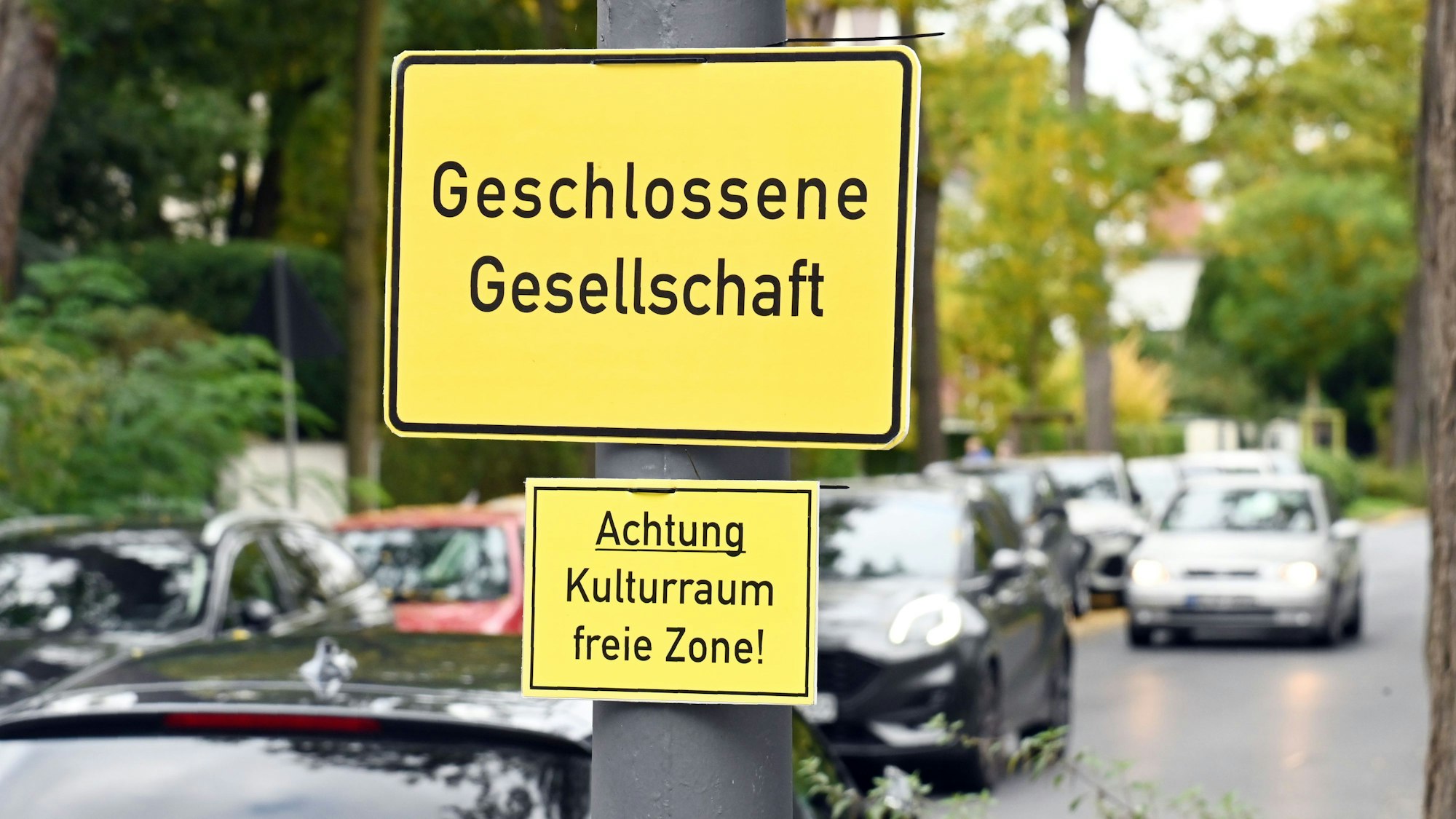 Auf einem Straßenschild steht „Geschlossene Gesellschaft“, auf einem kleineren darunter „Achtung Kulturraum freie Zone“.