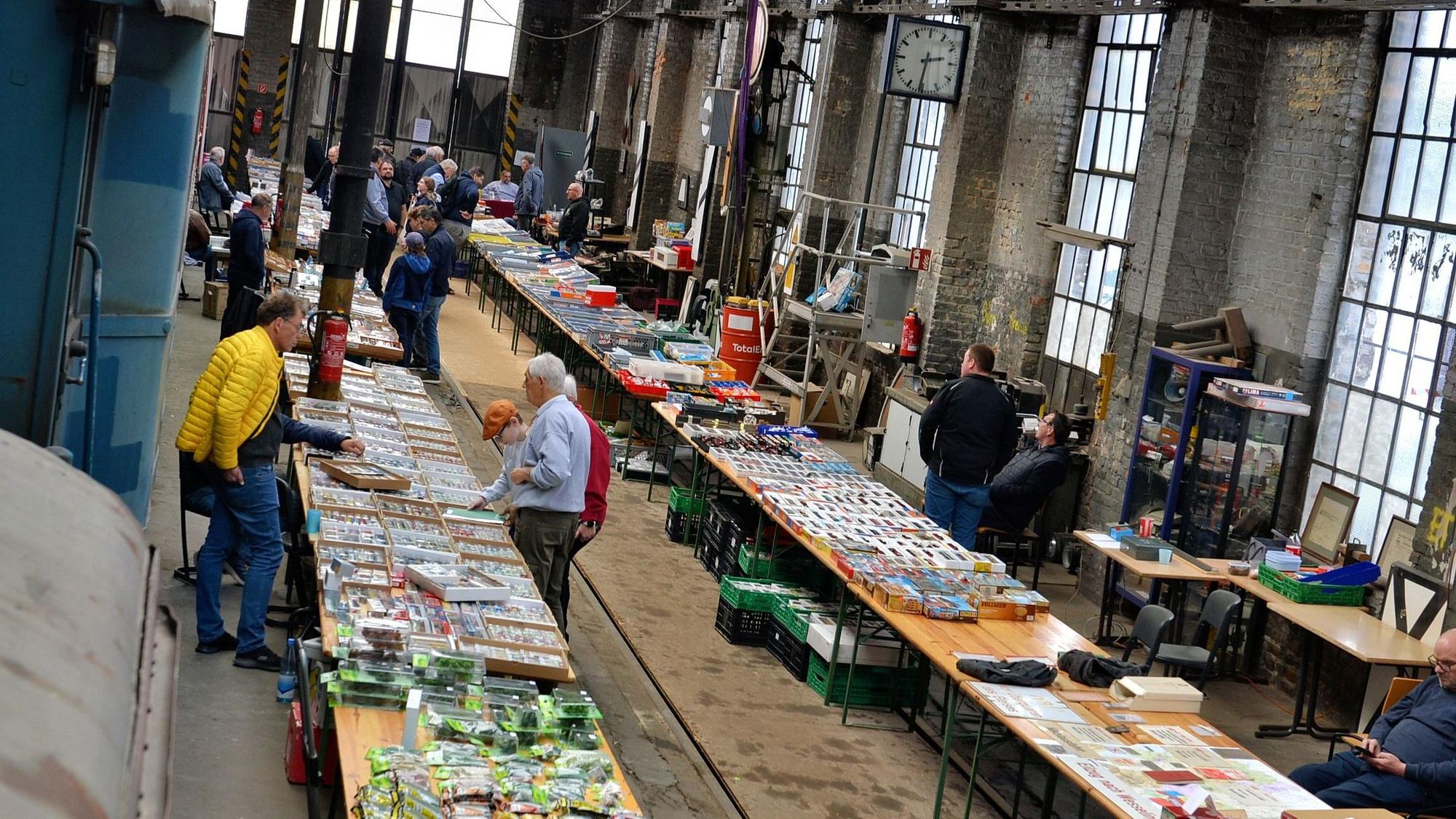 Im alten Lokschuppen in Euskirchen sind zahlreiche Biertische aufgebaut, auf denen Modelleisenbahnen und Zubehör angeboten werden.