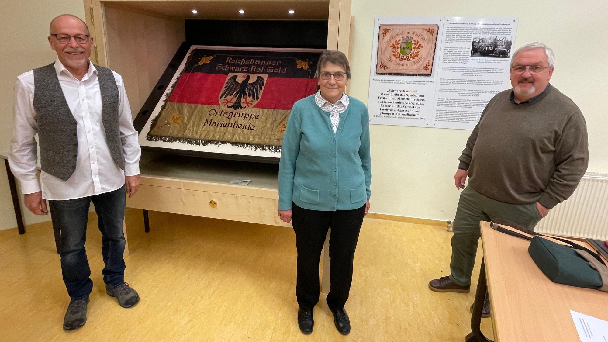 Mit der Fahne des Reichsbanners im Hintergrund stehen in einer Reihe: (v.l.) Werner Rosenthal, Bärbel Appenzeller und Stefan Meisenberg.