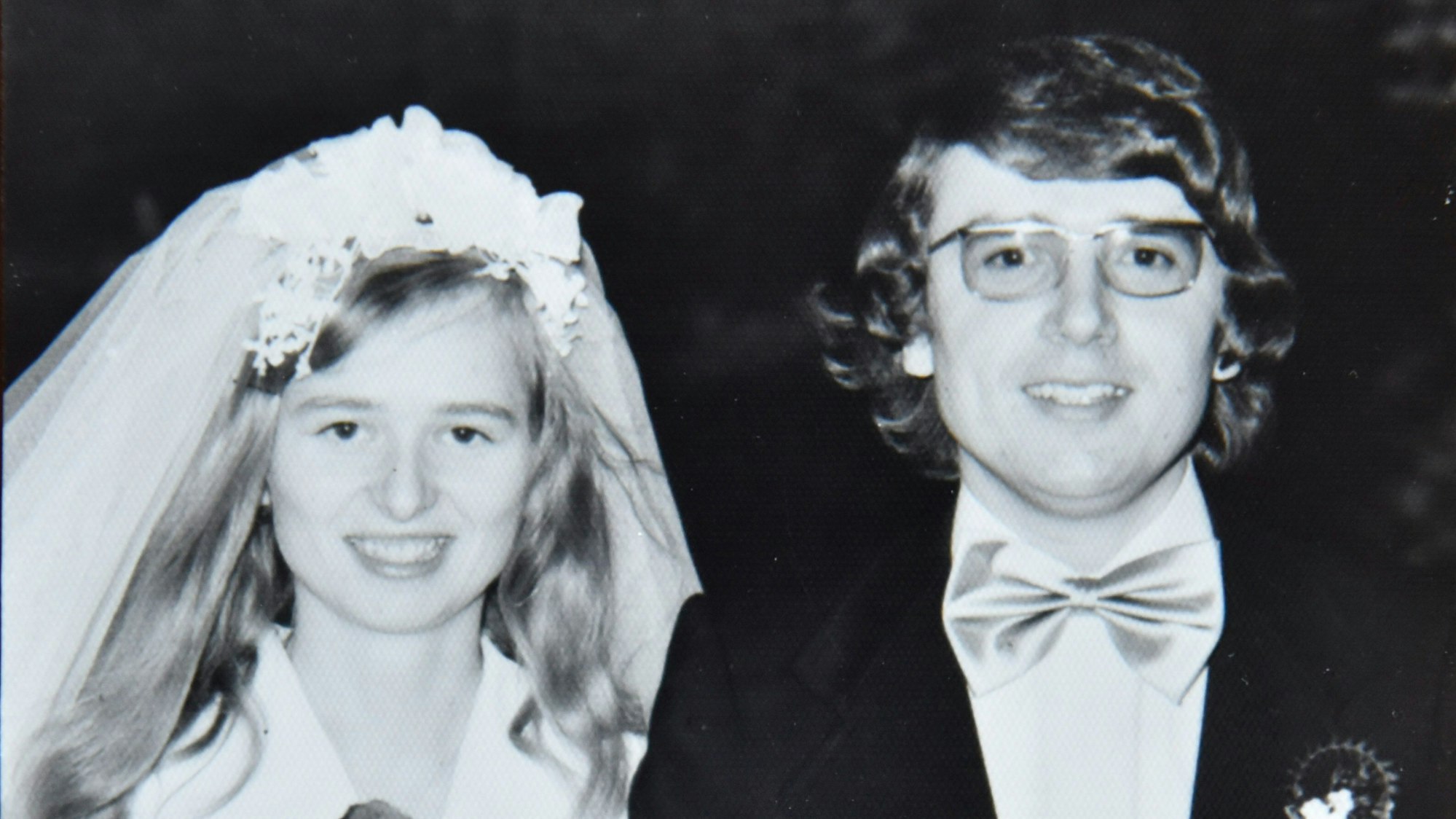 Das Bild zeigt das Paar in Hochzeitskleidung.