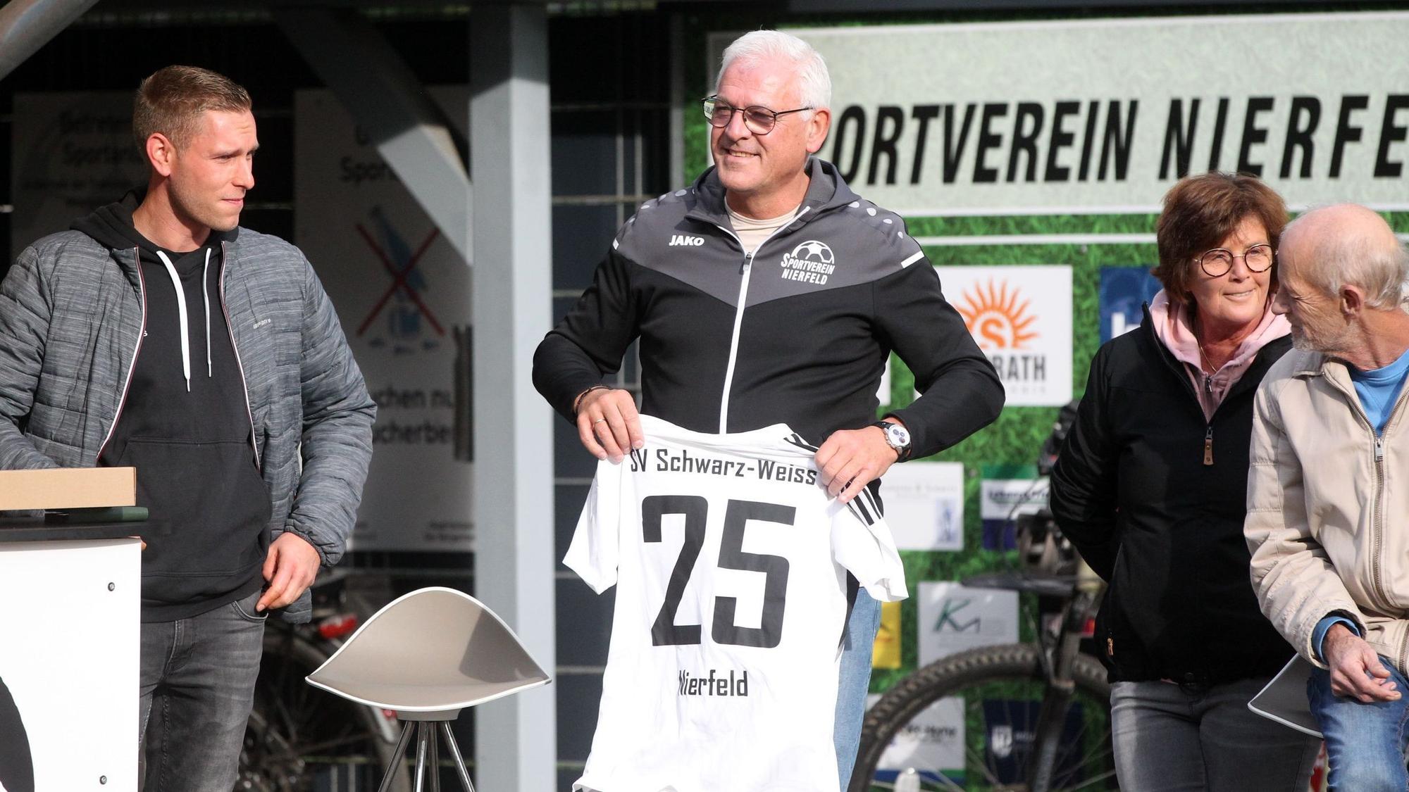 Das Bild zeigt Büser mit einem Trikot mit der Zahl 25 in den Händen.
