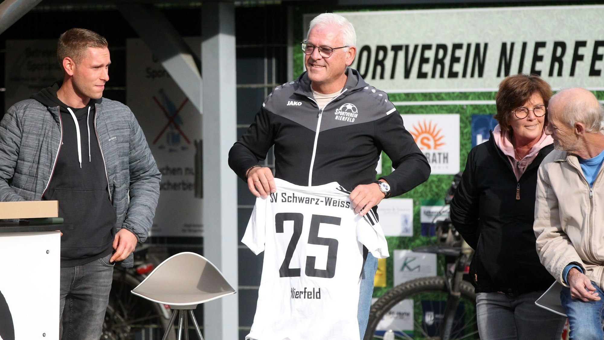 Das Bild zeigt Büser mit einem Trikot mit der Zahl 25 in den Händen.