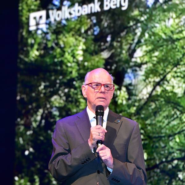 Der Politiker spricht mit Mikro in der Hand.