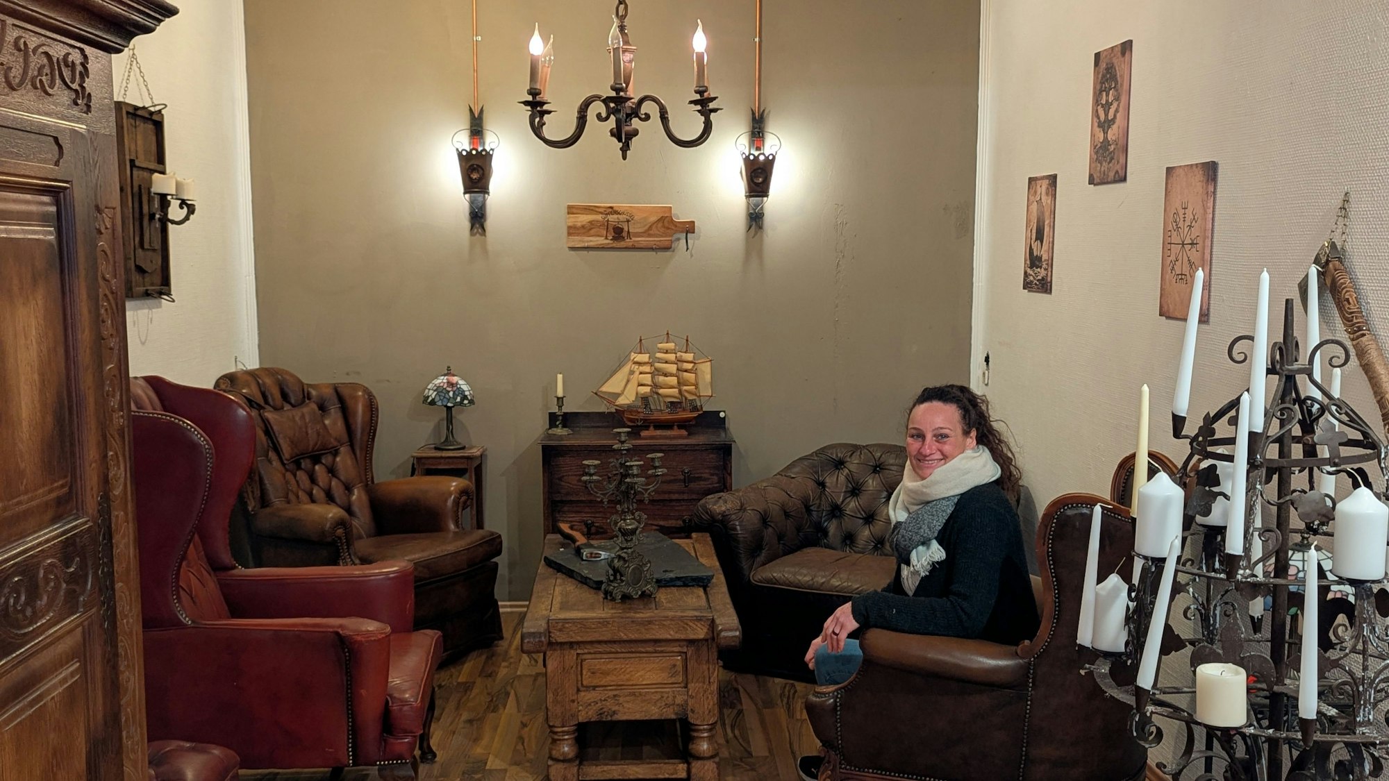 Das Foto zeigt die Inhaberin in einem Ledersessel im Partyraum.