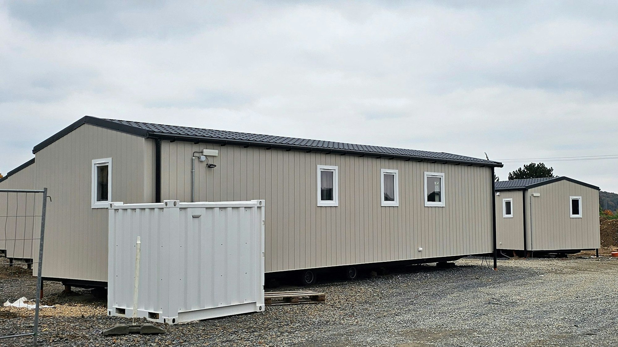 Zwei graubraune Tiny-Häuser stehen auf einer Baustelle in Kürten.