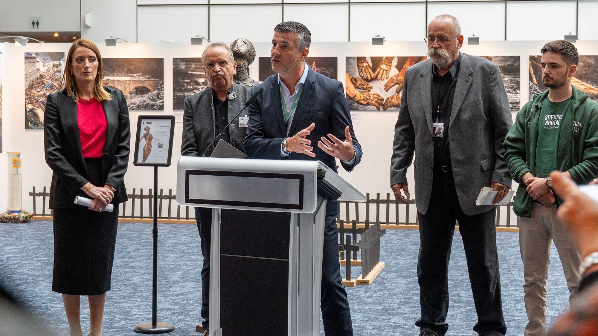 Der ostbelgische Abgeordnete Pascal Arimont spricht bei der Eröffnung der Ausstellung "Flut – Juli 2021. Eine Katastrophe im Herzen von Europa" im Europaparlament im Kreis von Roberta Metsola (v.l.), Ralph Orth, Klaus Jansen und Nick Falkner
