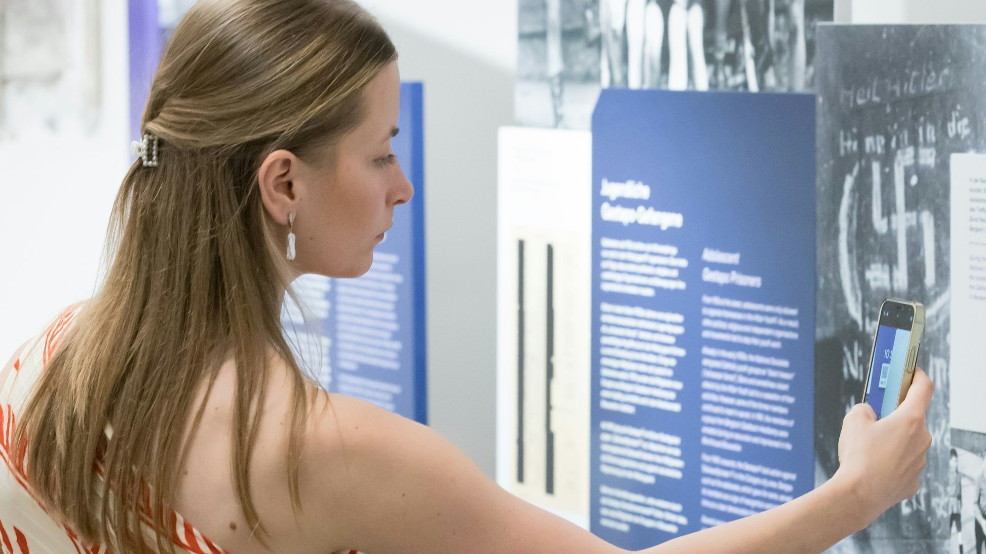 Eine Frau scannt einen QR-Code mit einem Smartphone.