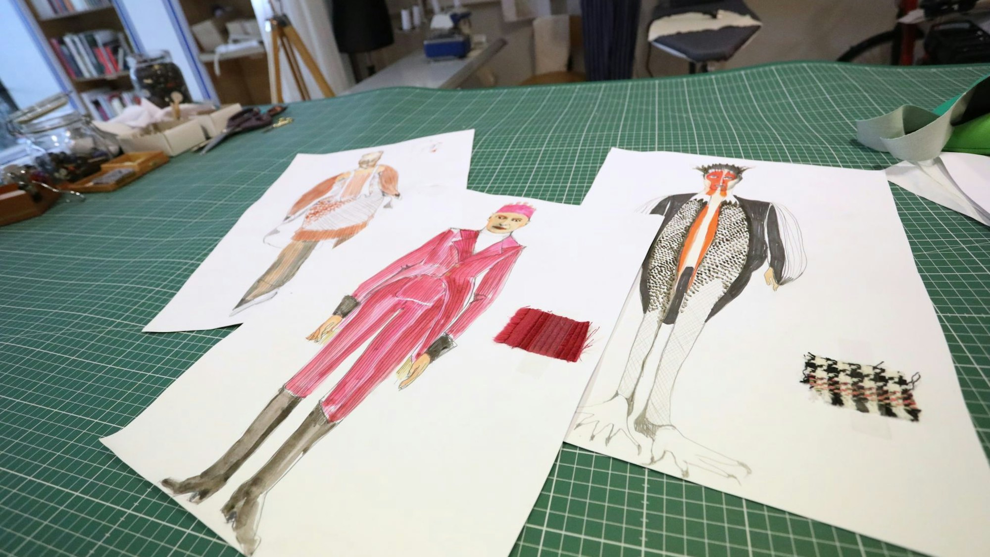 Drei Blätter mit gezeichneten Kostümentwürfen.