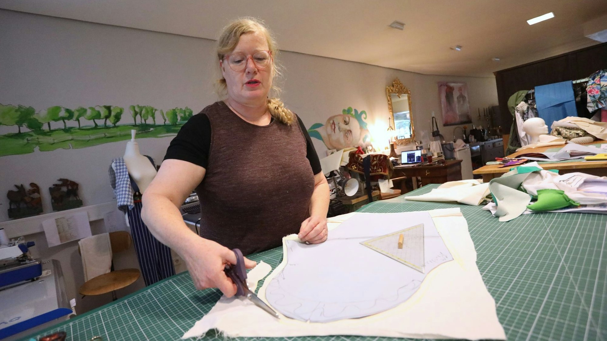 Eine Frau schneidet ein Stück Stoff zu.