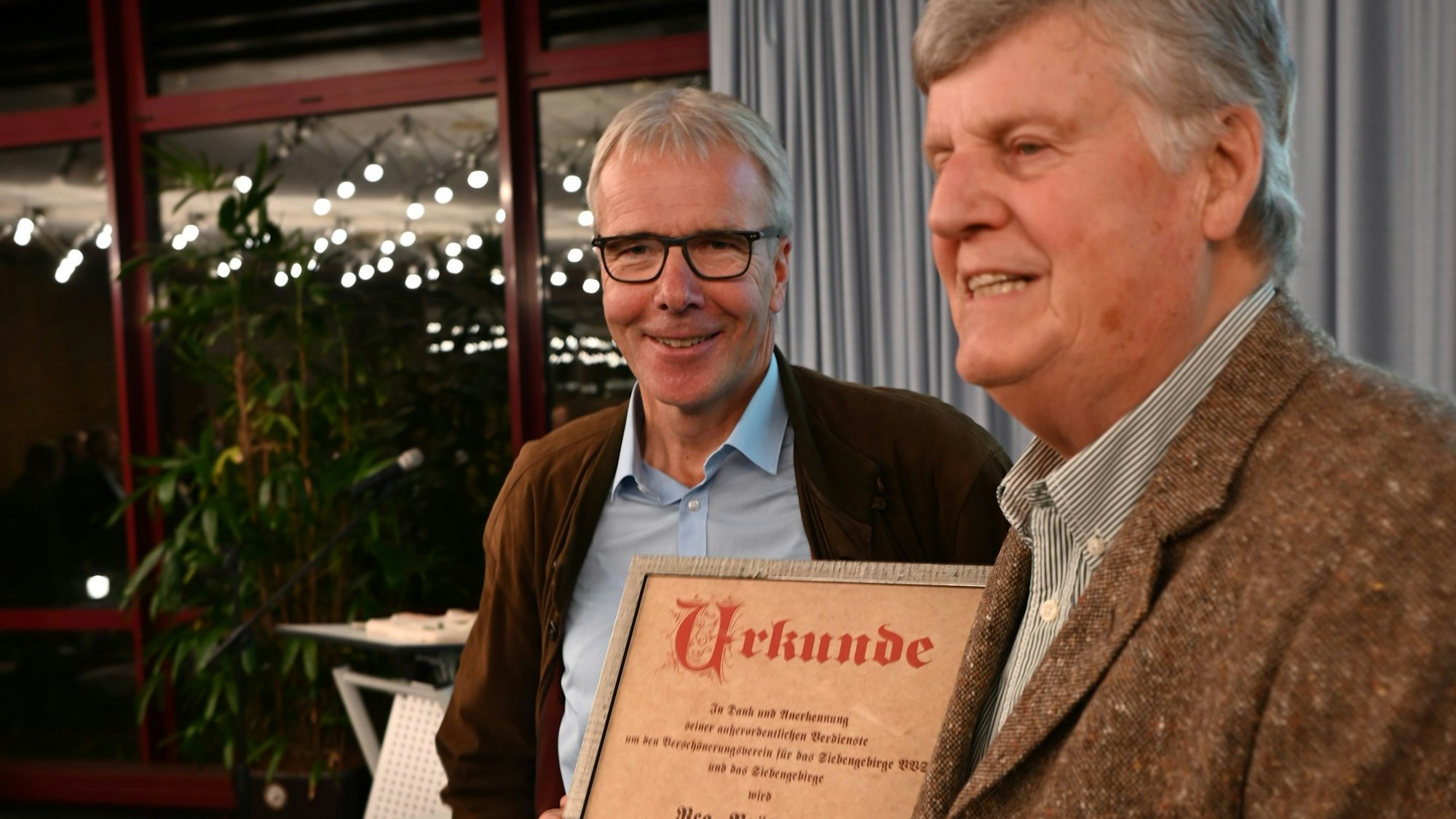 Zwei Männer mit einer Urkunde.