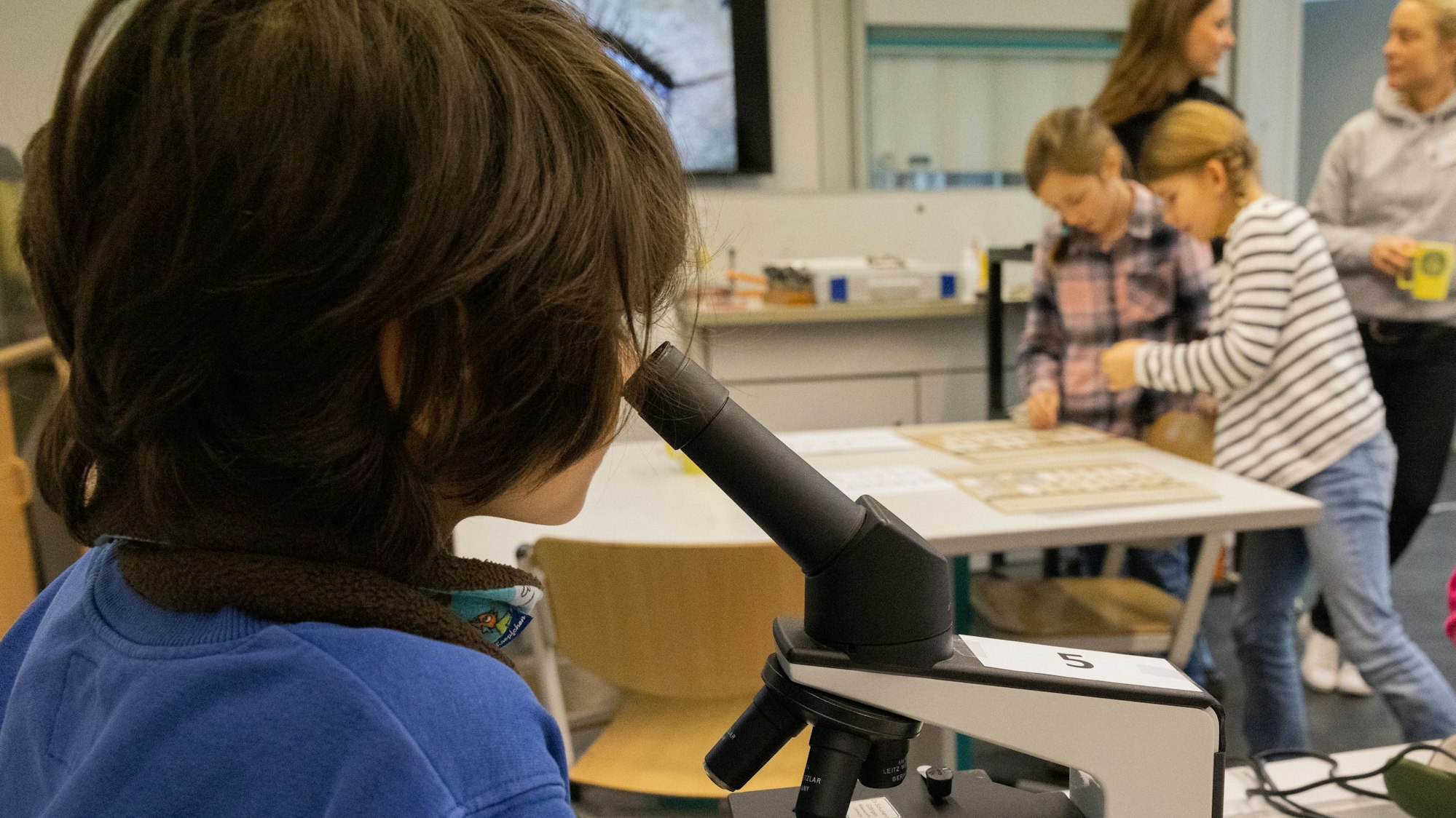 Ein Kind schaut durch ein Mikroskop.