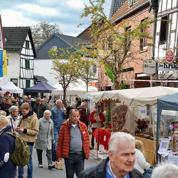 Besucher schlendern vorbei an den Ständen des Handwerkermarktes in Kommern.