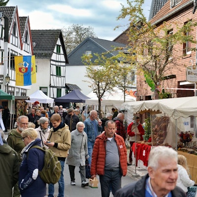 Besucher schlendern vorbei an den Ständen des Handwerkermarktes in Kommern.