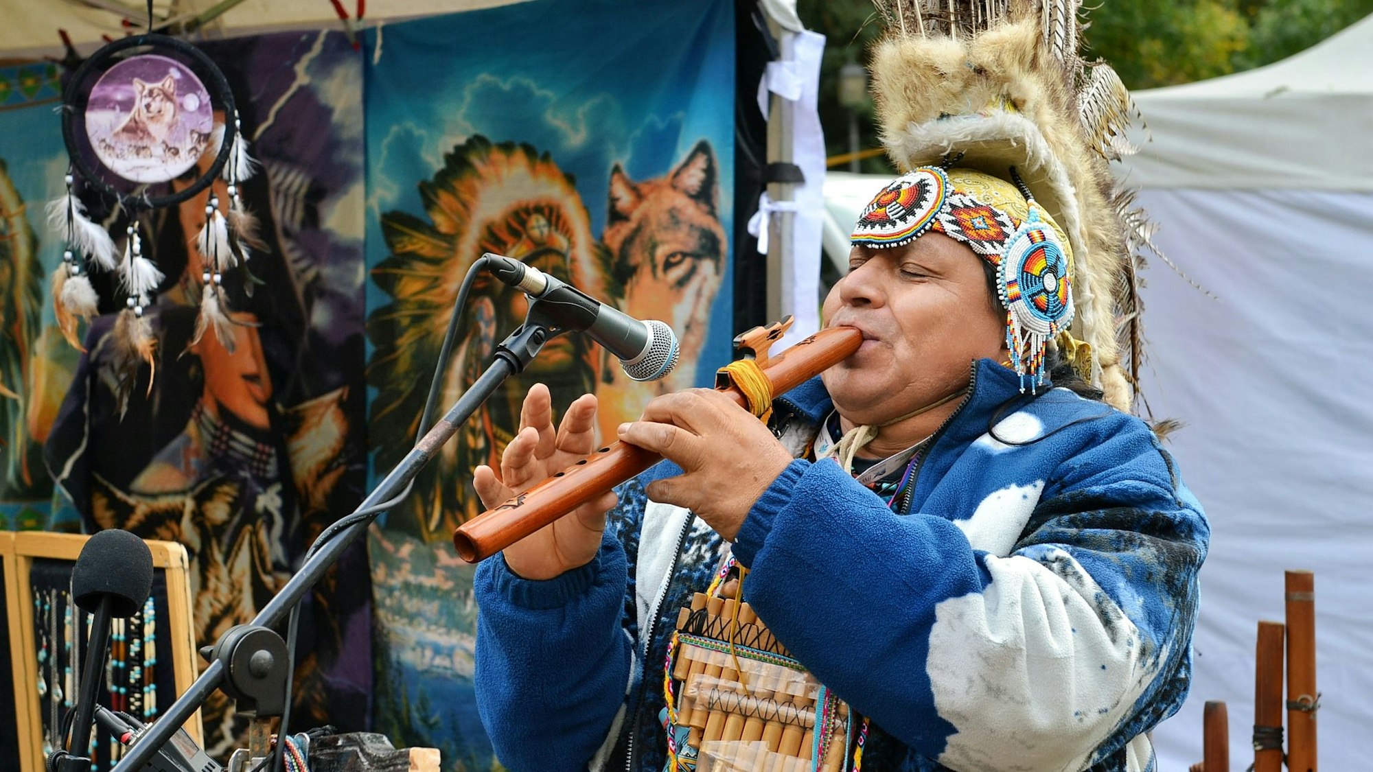 Das Bild zeigt den Obengenannten beim Spielen einer Flöte.