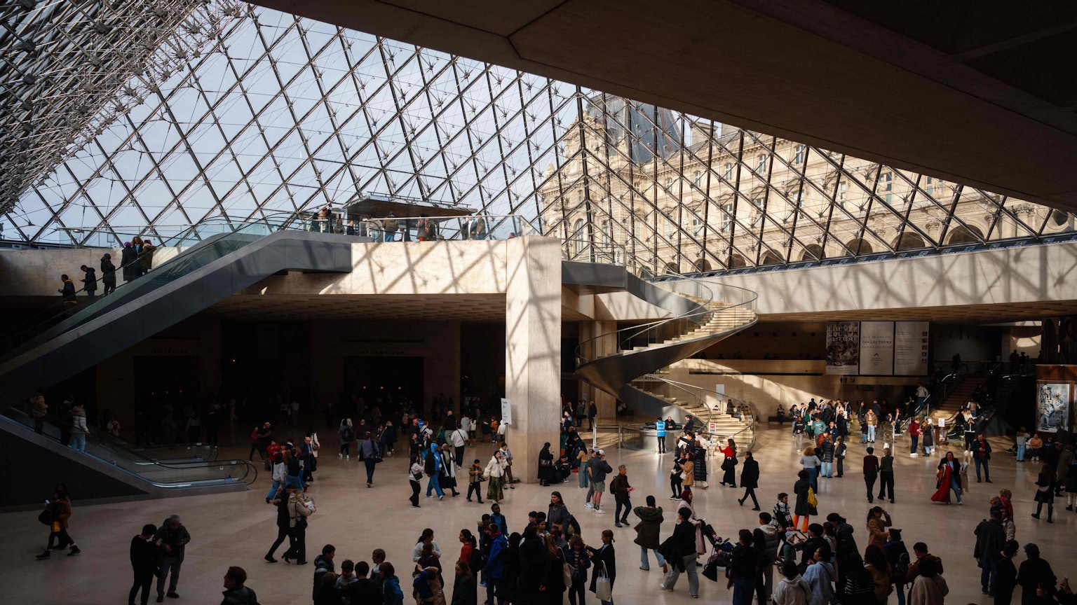Besucher gehen unter der Louvre-Pyramide im Louvre-Museum in Paris hindurch. (Symbolbild)
