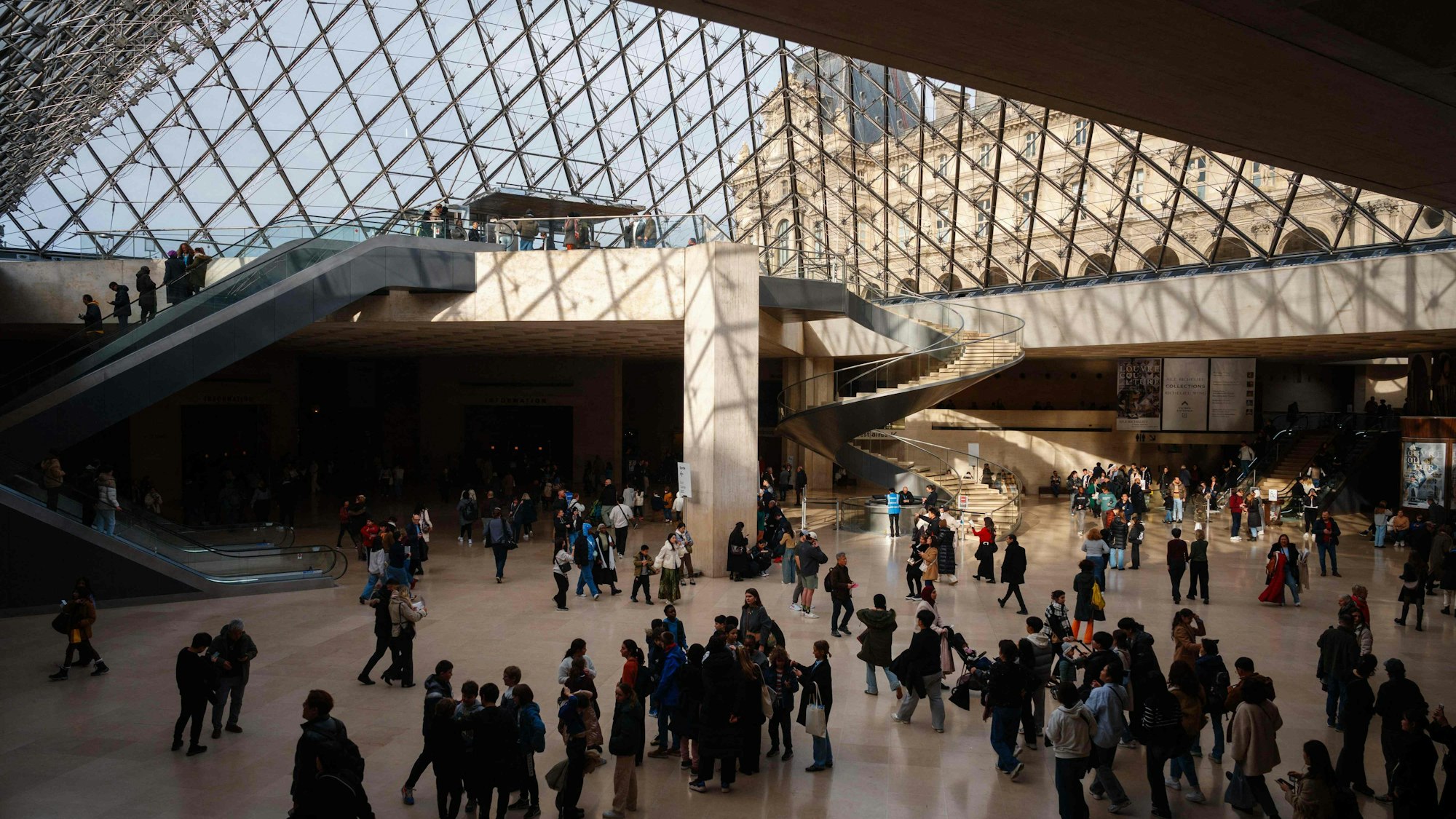 Besucher gehen unter der Louvre-Pyramide im Louvre-Museum in Paris hindurch. (Symbolbild)
