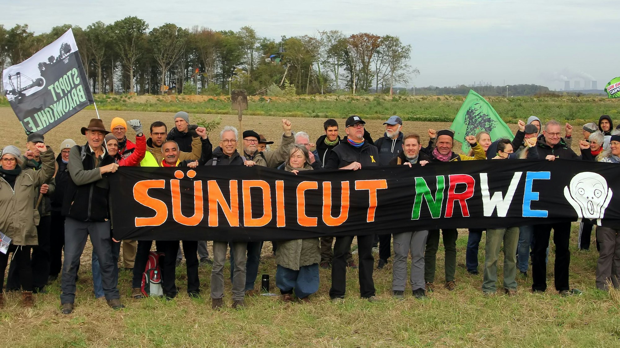 Das Foto zeigt Menschen bei einer Demo vor den Resten des Sündenwäldchens.