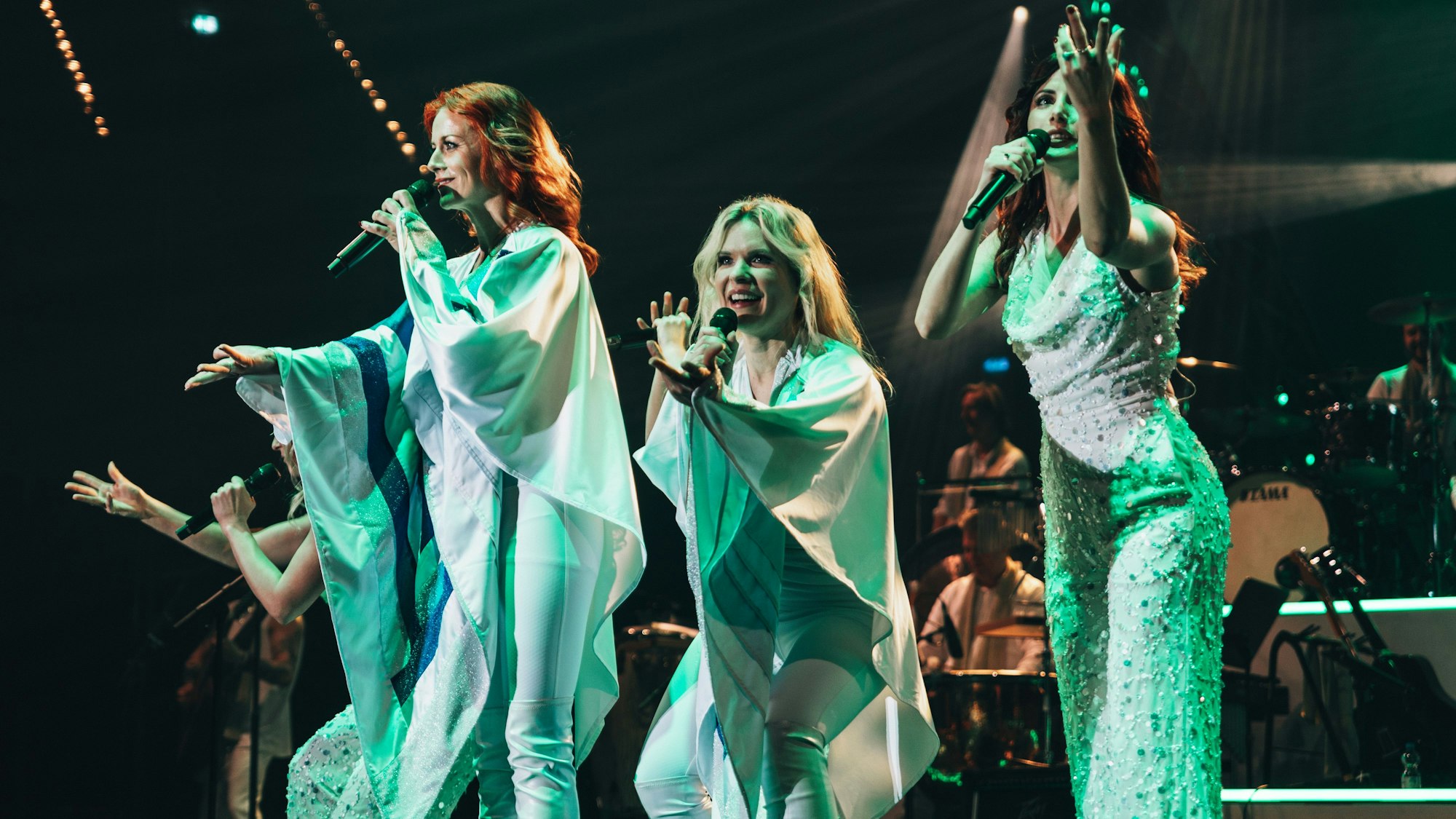 Drei Darstellerinnen von Abbamania in weißen Kostümen.