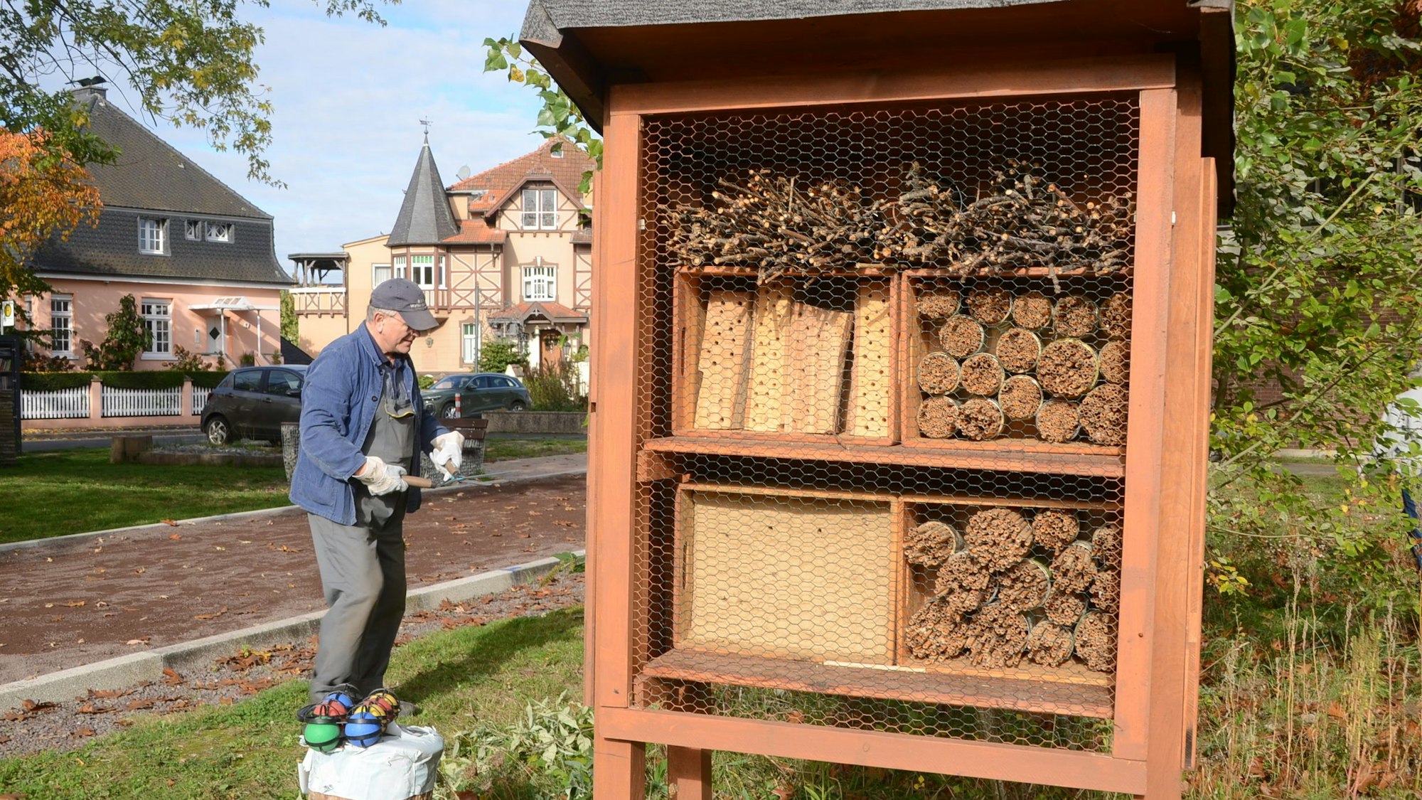 Ein Insektenhotel und eine Boulebahn, im Hintergrund stehen Wohnhäuser.