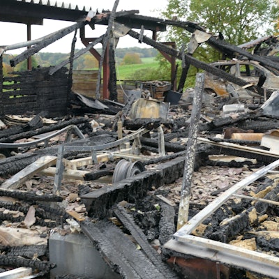 Die Ruine einer Halle und Brandschutt am Boden.