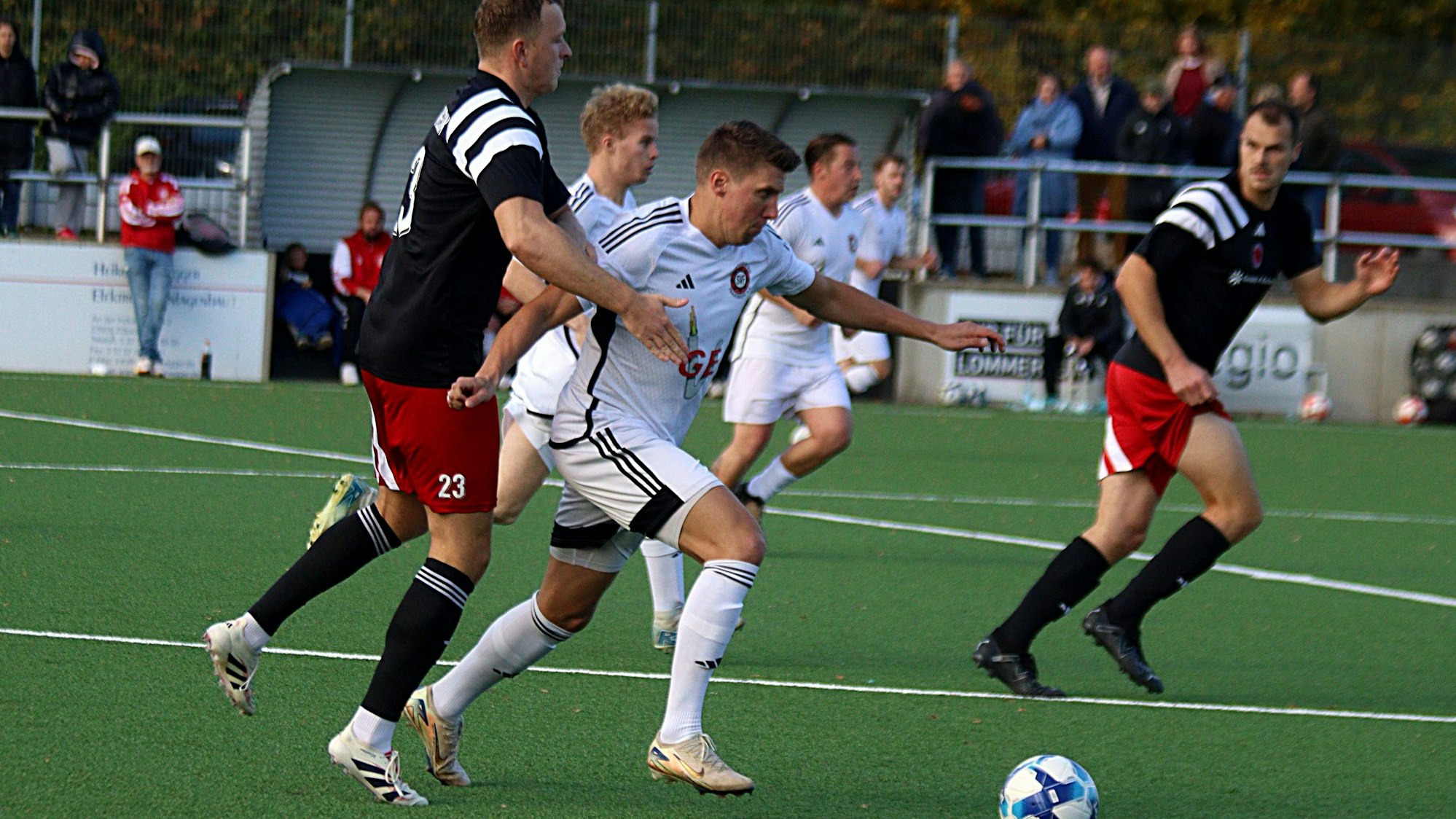 Voller Dynamik läuft Marcel Kaiser mit dem Ball, von hinten versucht Jan-Niklas Runkel den Spieler zu umklammern.