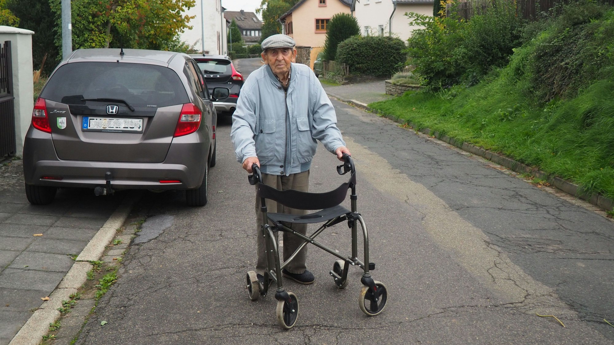 Hubert Geusen geht mit seinem Rollator die Dorfstraße entlang.